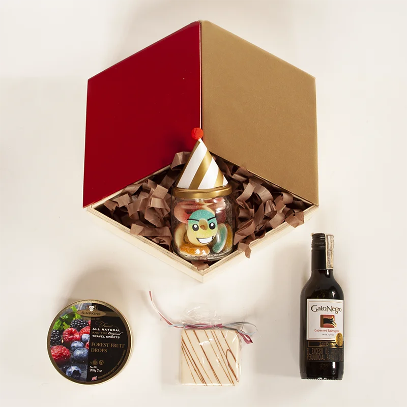 Caja hexagonal con botella de vino gato negro, alfajor, dulces ingleses y tarjeta personalizada. 
